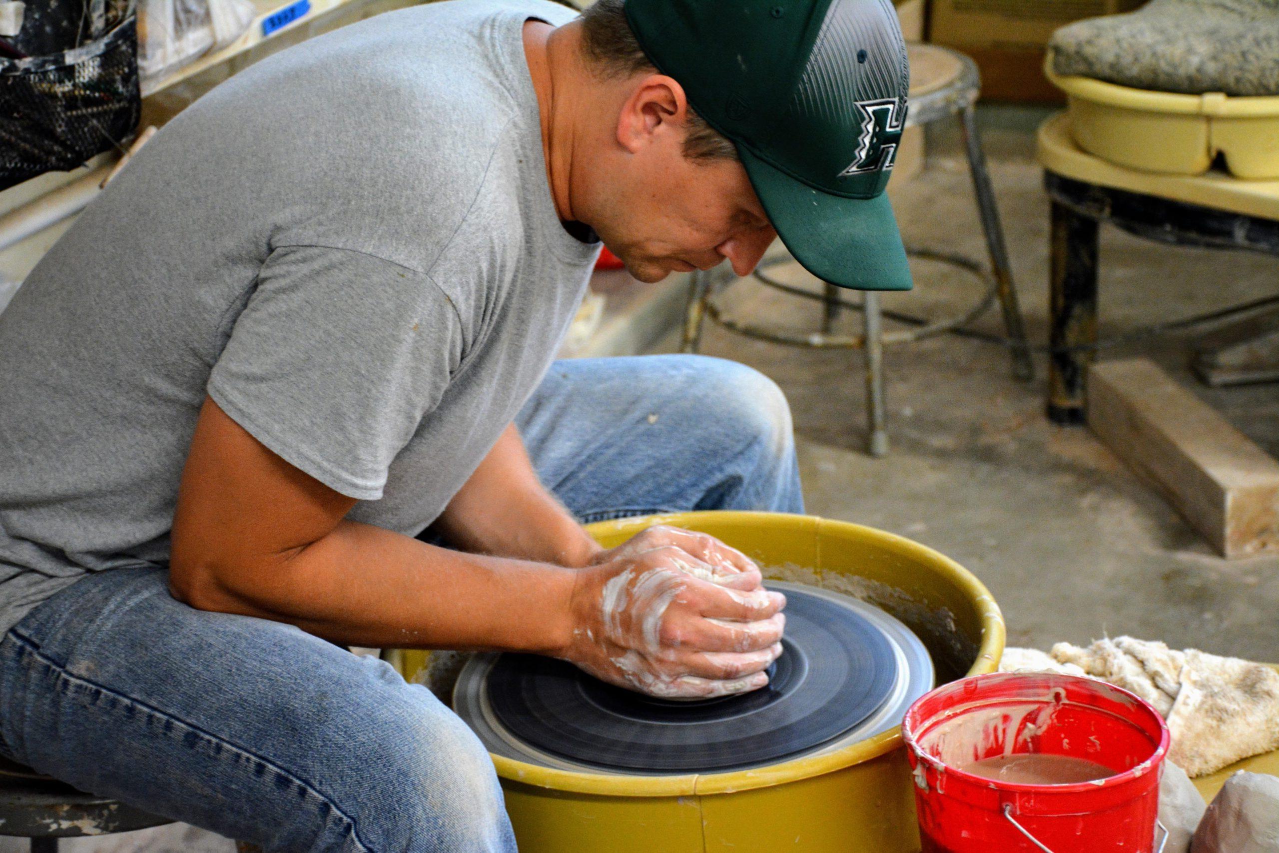 Student working with pottery wheel